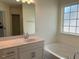 Bathroom featuring white cabinets, bathtub and shower combo, large mirror, and natural light at 253 Plains Dr # 264, Burlington, NC 27217