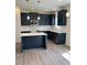 Modern kitchen features dark blue cabinetry, a center island, stainless steel appliances and wood floors at 253 Plains Dr # 264, Burlington, NC 27217