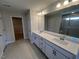 Bathroom featuring a shower, dual sink vanity and large mirror at 120 Wild Turkey Way, Lillington, NC 27546