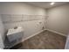 Functional laundry room with a utility sink, wire shelving, and tiled flooring at 120 Wild Turkey Way, Lillington, NC 27546