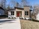 Modern home with unique design elements, neutral siding, and a vibrant orange front door at 173 Nashua Dr, Louisburg, NC 27549