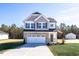 Two-story house with gray siding, stone accents, and a white garage door at 211 Wild Turkey Way, Lillington, NC 27546
