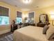 Bedroom with warm yellow walls, hard wood floors, and large windows with natural light at 2501 Kenmore Dr, Raleigh, NC 27608