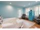 Bright bedroom with blue walls, wood floors, shuttered windows, and a vintage blue safe at 2501 Kenmore Dr, Raleigh, NC 27608