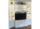 Built-in shelving with glass shelves, cabinet storage, and space for a TV at 2501 Kenmore Dr, Raleigh, NC 27608