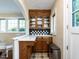 Butler pantry area featuring wood cabinets, tile backsplash, and a built-in sink at 2501 Kenmore Dr, Raleigh, NC 27608