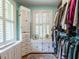 Walk-in closet featuring white storage units, shuttered windows, and clothing racks at 2501 Kenmore Dr, Raleigh, NC 27608