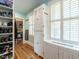 Organized walk-in closet with built-in shelving and natural light from window with shutters at 2501 Kenmore Dr, Raleigh, NC 27608