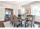 Cozy dining room with hardwood floors, chandelier, many windows and access to an adjacent sunroom at 2501 Kenmore Dr, Raleigh, NC 27608
