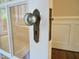 Vintage glass doorknob and tarnished hardware on a white door leading to sunroom at 2501 Kenmore Dr, Raleigh, NC 27608