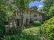 Stone home featuring mature landscaping, a lush yard, and classic architectural details at 2501 Kenmore Dr, Raleigh, NC 27608