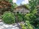 Stately stone house with mature landscaping, lush hedges and shade trees at 2501 Kenmore Dr, Raleigh, NC 27608
