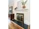 Close up of an elegant fireplace featuring black and gold features, with hardwood floors at 2501 Kenmore Dr, Raleigh, NC 27608