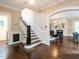 Elegant foyer features hardwood floors, chandelier lighting, and flows into the living room with fireplace at 2501 Kenmore Dr, Raleigh, NC 27608