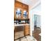 Kitchen pantry area displaying glass door cabinets, stainless mini fridge, and decorative backsplash tiles at 2501 Kenmore Dr, Raleigh, NC 27608