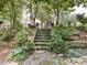 Elegant stone steps with moss accents, surrounded by mature landscaping and lush foliage at 2501 Kenmore Dr, Raleigh, NC 27608