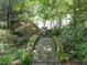 Scenic stone bridge surrounded by mature trees and landscaping, creating a serene outdoor space at 2501 Kenmore Dr, Raleigh, NC 27608