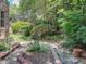Lush landscaped yard with mature trees, manicured shrubs, and garden features at 2501 Kenmore Dr, Raleigh, NC 27608