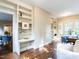 Office features hardwood floors, built-in bookcases and a view into the sunroom at 2501 Kenmore Dr, Raleigh, NC 27608