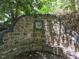 Unique stone bench featuring custom stonework and integrated design surrounded by lush greenery at 2501 Kenmore Dr, Raleigh, NC 27608