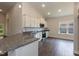 Open kitchen with granite countertops, white cabinets and stainless steel appliances at 67 Decatur Dr, Fuquay Varina, NC 27526
