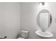 Bright bathroom showcasing a pedestal sink, oval mirror, and white fixtures at 3113 Petrea Ct # 38, Angier, NC 27501