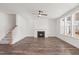Bright living room with fireplace, wood floors, modern ceiling fan, and stair access at 3113 Petrea Ct # 38, Angier, NC 27501