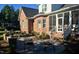 Serene backyard patio with stylish seating and lush greenery, next to brick house with screened in porch at 6352 River Rd, Fuquay Varina, NC 27526