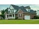 Charming brick home with a covered front porch, an attached garage, and well-manicured lawn at 6352 River Rd, Fuquay Varina, NC 27526
