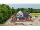New two-story brick home with a dark roof and covered porch nestled on a wooded lot at 6352 River Rd, Fuquay Varina, NC 27526