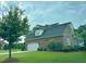Brick house with a covered front porch, an attached garage, and a well-maintained green lawn at 6352 River Rd, Fuquay Varina, NC 27526