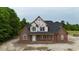 An elegant new two-story brick house featuring large windows and a covered front porch under construction at 6352 River Rd, Fuquay Varina, NC 27526