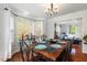Elegant dining room with a bay window, modern chandelier, and wood floors adjacent to a comfortable living space at 135 Deep Creek, Rougemont, NC 27572