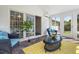 Cozy sunroom with wicker furniture, bright yellow rug, and multiple access points to the outdoors at 135 Deep Creek, Rougemont, NC 27572