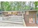The back of the brick house features a multi-level deck for outdoor enjoyment in the wooded backyard at 128 Dixie Dr, Chapel Hill, NC 27514