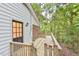 Backyard view featuring an exterior door, and a wooden deck in a wooded setting at 128 Dixie Dr, Chapel Hill, NC 27514