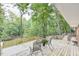 Spacious wooden deck with chairs offers a tranquil outdoor space surrounded by lush trees and natural beauty at 128 Dixie Dr, Chapel Hill, NC 27514
