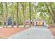 Charming home with brick accents, white siding, black shutters, and a spacious gravel driveway surrounded by mature trees at 128 Dixie Dr, Chapel Hill, NC 27514