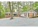 Inviting home showcases a brick exterior, white siding, black shutters, and a generous gravel driveway at 128 Dixie Dr, Chapel Hill, NC 27514