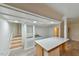Open concept living room with an island, wet bar, and light gray wood flooring at 128 Dixie Dr, Chapel Hill, NC 27514