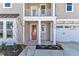 Inviting front porch with an orange door, white columns, and a second-story balcony above at 3109 Petrea Ct # 39, Angier, NC 27501