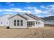 Back exterior view of a beige home with a covered porch and a lawn waiting for new grass at 3109 Petrea Ct # 39, Angier, NC 27501