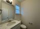 Well-lit powder room featuring granite countertops, white cabinets, and a modern faucet and lighting fixture at 490 Traditions Grande Blvd # 27, Wake Forest, NC 27587