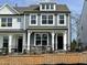 Charming two-story home featuring a stylish mix of light gray and white siding and black wrought iron fencing at 490 Traditions Grande Blvd # 27, Wake Forest, NC 27587
