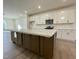 Modern kitchen boasts white cabinets, stainless steel appliances, and a large island with marble countertop at 490 Traditions Grande Blvd # 27, Wake Forest, NC 27587