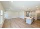 Open-concept living room with island and modern white kitchen at 9229 Kitchin Farms Way # 427, Wake Forest, NC 27587