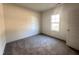 Bright bedroom with carpeted floor, large window, and a door at 64 Lupin Dr, Smithfield, NC 27577