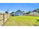 Back view of home featuring a newly fenced-in yard with healthy lawn at 306 E Godwin St, Dunn, NC 28334