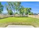 Large backyard featuring mature trees, lush green grass, and a new wooden fence at 306 E Godwin St, Dunn, NC 28334