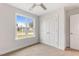 Bright bedroom featuring neutral carpet, ceiling fan, large window and a double door closet at 306 E Godwin St, Dunn, NC 28334